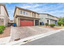 Charming two-story home featuring a red garage door and a meticulously paved driveway at 11228 Burning River St, Las Vegas, NV 89183