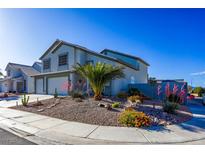 Charming two-story home with a two-car garage and desert landscaping, including a palm tree and colorful flowering shrubs at 7800 Four Seasons Dr, Las Vegas, NV 89129