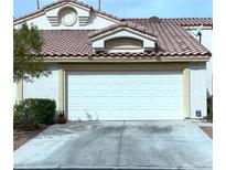 Attached home featuring a white garage door, desert landscaping and red tile roof at 855 N Stephanie St # 112, Henderson, NV 89014