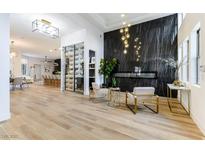 Bright and open living space with a modern fireplace, wood floors, and wine storage at 1350 Rossini St, Henderson, NV 89052