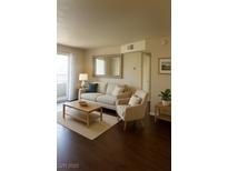 Bright living room with modern furniture, dark wood floors, and a large mirror at 2606 S Durango Dr # 277, Las Vegas, NV 89117