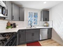 Modern kitchen features stainless steel appliances, gray cabinetry, and white countertops at 2724 Spear St, North Las Vegas, NV 89030