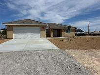 Charming single-story home featuring a two-car garage, neutral stucco, and tile roof at 3016 Mount Charleston Dr, Pahrump, NV 89048