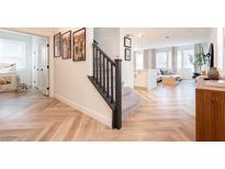 Inviting entryway with beautiful wood-look floors, open staircase and views of the living room space at 4707 Pink Jasper Ct, Las Vegas, NV 89141
