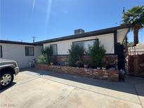 Modest single-story home featuring a brick-lined garden bed and desert landscaping at 6117 Cromwell Cir, Las Vegas, NV 89107