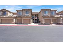 Attractive condo complex showcasing garages, stairwells, and beige stucco exteriors at 6680 Caporetto Ln # 103, North Las Vegas, NV 89084