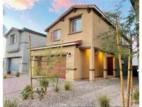 Two-story home featuring a red garage door, complemented by a red front door and a well-maintained landscape at 7892 W Shelbourne Ave, Las Vegas, NV 89113
