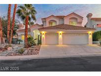 Charming two-story home with a tile roof, three car garage, and desert landscaping at sunset at 8125 Sunset Cove Dr, Las Vegas, NV 89128