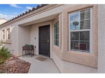 Welcoming front entrance with secure door, neutral stucco, and a planter box for added charm at 9284 Lopseed Ct, Las Vegas, NV 89149