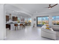 Open-concept living area featuring a modern kitchen, dining space, and comfortable seating with mountain views at 1130 Calico Rdg, Mesquite, NV 89034