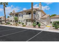 Low-rise residential building featuring stucco siding, private balconies and assigned parking in a gated community at 921 Sulphur Springs Ln # 201, Las Vegas, NV 89128