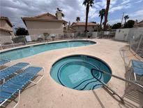 Community pool and hot tub with lounge chairs and palm trees at 921 Sulphur Springs Ln # 201, Las Vegas, NV 89128