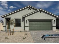 Charming single-story home with desert landscaping, a two-car garage, and a neutral color palette at 3240 Walker River St, North Las Vegas, NV 89032