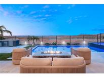 Outdoor pool area with modern seating and fire pit overlooking scenic desert landscape at 36 Thorn Creek St, Henderson, NV 89011