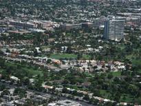 Overhead shot of a residential area, highlighting lush greenery, scattered homes, and buildings in the distance at 682 Oakmont Ave # 1507, Las Vegas, NV 89109