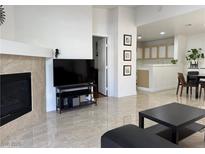 Bright living room with fireplace, tile flooring, and open layout leading to the kitchen and dining area at 8452 Boseck Dr # 225, Las Vegas, NV 89145