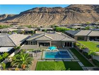 An aerial view of a private pool, landscaping, and outdoor living space with mountain views at 10004 Terrastone Dr, Las Vegas, NV 89148