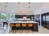 Modern kitchen featuring an island with seating, stainless steel appliances, and pendant lighting at 176 Tierra Bonita Ct, Henderson, NV 89074