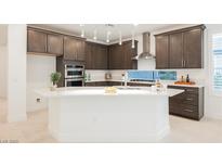 Modern kitchen features dark wood cabinetry, stainless steel appliances, and a large white island with sink at 19 Desert Ivy Ln, Henderson, NV 89011