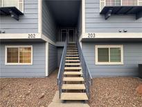 Inviting condo exterior with light blue siding and stairs leading to upper-level units at 5320 Portavilla Ct # 203, Las Vegas, NV 89122