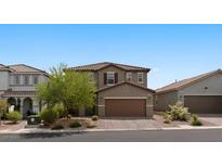 Two-story home with desert landscaping, brown trim, and a two car garage in a planned community at 6955 Elysian Valley Ave, Las Vegas, NV 89113