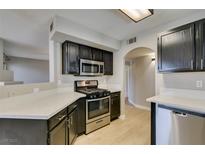 Modern kitchen featuring stainless steel appliances, dark wood cabinets, and light countertops at 698 S Racetrack Rd # 114, Henderson, NV 89015