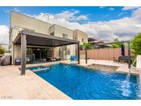 Backyard pool with patio furniture, swings, and a spiral staircase to the second floor at 731 Glowing Horizon St, Henderson, NV 89052