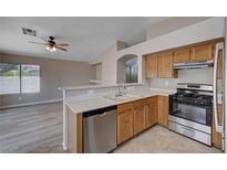 Well-lit kitchen featuring stainless steel appliances, oak cabinets, and a breakfast bar at 8028 Hurricane Cove Ct, Las Vegas, NV 89129