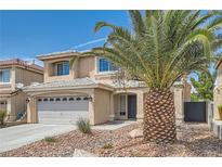 Two-story home with tan stucco, two car garage, rock landscaping and mature palm tree at 890 Socorro Song Ln, Henderson, NV 89052