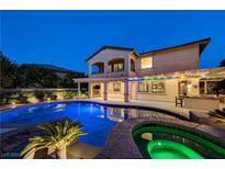 Inviting backyard pool with hot tub, outdoor kitchen, and covered patio perfect for evening relaxation and entertaining at 12122 High Country Ln, Las Vegas, NV 89138