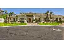 Well-maintained home with lush landscaping, mature palm trees, and circular driveway at 1508 Ten Palms Ct, Las Vegas, NV 89117