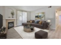 Bright living room featuring a fireplace, neutral paint, and sliding glass door for outdoor access at 1830 N Buffalo Dr # 1091, Las Vegas, NV 89128
