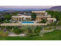 Expansive home featuring a pool and lush landscaping, set against a mountain backdrop at 28 Painted Feather Way, Las Vegas, NV 89135