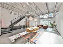 Spacious open-plan living area with soaring ceilings, a modern staircase and a large window view at 5077 Thunder River Cir, Las Vegas, NV 89148