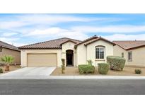 Charming single-story home with a tile roof, inviting entrance, desert landscaping, and a two-car garage at 8220 Redbud Vine St, North Las Vegas, NV 89085