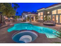 Inviting backyard pool and spa with an outdoor kitchen and covered lounge area, perfect for entertaining at 8808 Rozetta Ct, Las Vegas, NV 89134