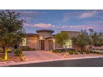 Beautiful home exterior featuring professional landscaping, brick driveway and tasteful outdoor lighting at 9928 Regency Square Ave, Las Vegas, NV 89148