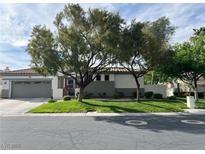 Charming single-story home featuring mature trees, lush lawn, and a gray two-car garage, offering a welcoming curb appeal at 2964 Via Della Amore, Henderson, NV 89052