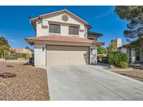 Two-story home featuring a tile roof, a spacious driveway, and a beige two car garage in a well maintained neighborhood at 5044 Signal Dr, Las Vegas, NV 89130