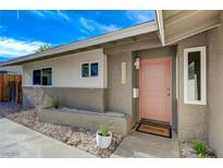 Charming home featuring a unique pink door, textured exterior, and stylish front yard landscaping at 5904 Apple Valley Ln, Las Vegas, NV 89108