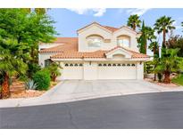 Charming stucco home with a tile roof, three-car garage, and mature landscaping at 8117 Horizon Lake Dr, Las Vegas, NV 89128