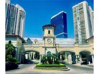 Grand entrance to a luxury high-rise community with lush landscaping and an elegant clock tower between tall buildings at 2857 Paradise Rd # 3603, Las Vegas, NV 89109