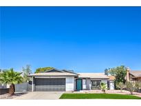 Charming single-story home featuring a well-maintained front yard and a gray two-car garage door at 4012 Mira Ln, Las Vegas, NV 89108