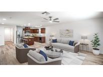 Bright, open-concept living area with wood floors, ceiling fan, and neutral color palette at 10085 S Riley St, Las Vegas, NV 89178