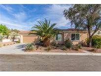 Charming home featuring desert landscaping, a two-car garage, and a palm tree in the front yard at 2489 Black River Falls Dr, Henderson, NV 89044