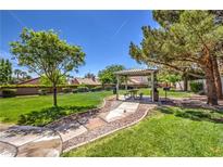 Outdoor community area featuring a picnic table, bbq, lush lawn, and mature shade trees at 8942 Galena Crossing St, Las Vegas, NV 89123