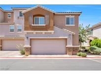 Charming two-story townhome featuring a stucco facade, two-car garage and well-maintained landscaping at 9981 Sable Point St, Las Vegas, NV 89178