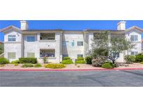 Well-maintained condo building with lush landscaping and a vibrant red rock ground covering at 2117 Echo Bay St # 102, Las Vegas, NV 89128