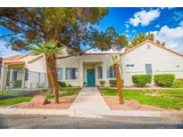 Inviting single-story home with desert landscaping, mature trees, and a charming turquoise front door at 2251 Van Gogh Dr, Henderson, NV 89074