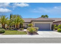 Charming single-story home featuring a well-manicured lawn, mature palm trees, and a two-car garage at 2295 Otter Rock Ave, Henderson, NV 89044